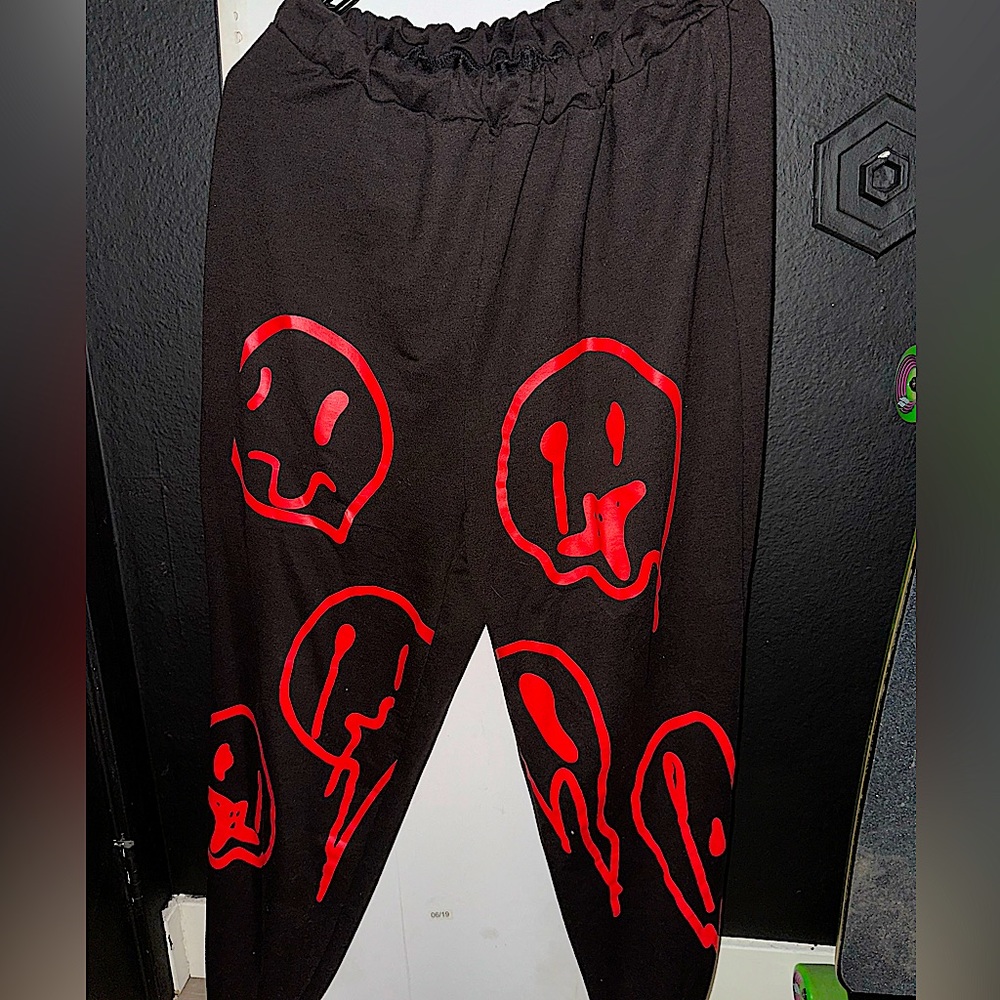 Black women’s sweatpants with red smiley faces on the front